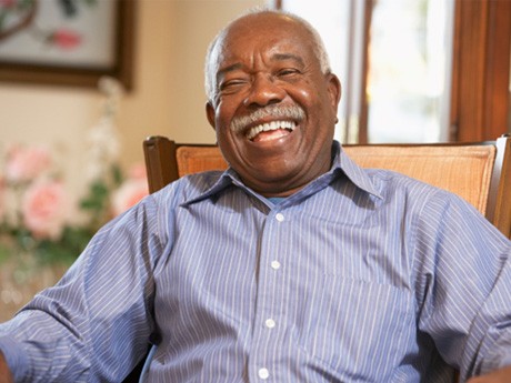 Senior man sitting in chair and laughing  