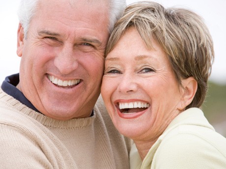 Senior man and woman hugging and smiling  