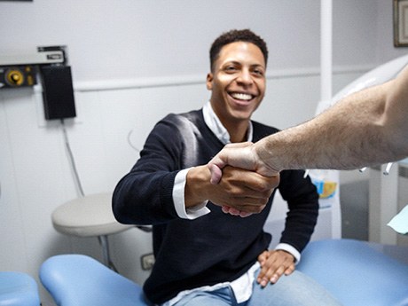 Patient standing up and shaking dentist’s hand