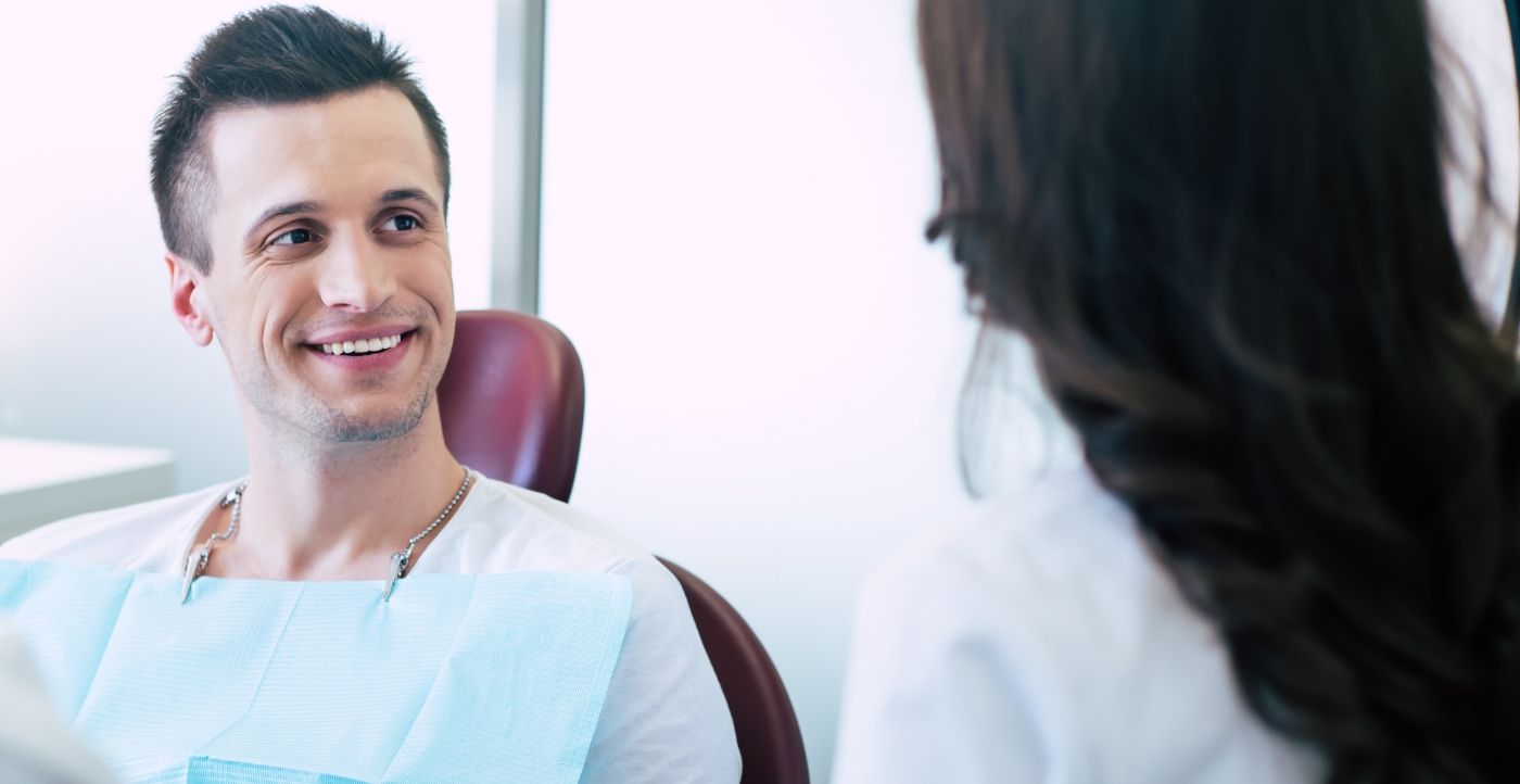 Man in dental treatment chair smiling
