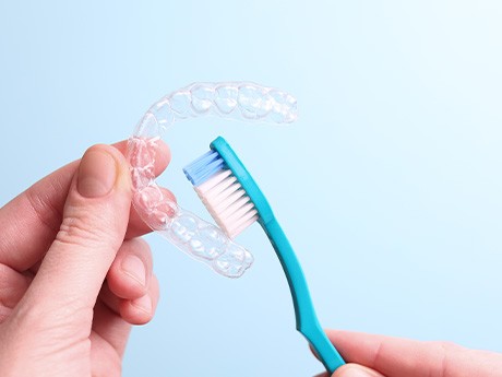 Patient cleaning clear aligner with toothbrush