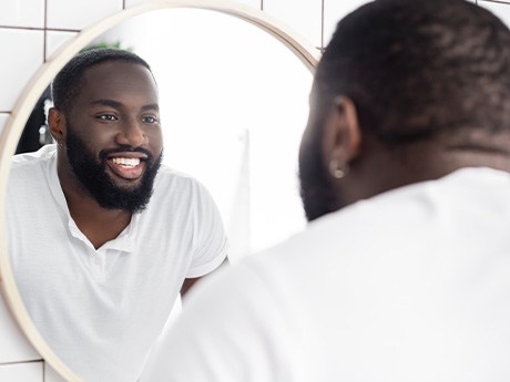 Man smiling at reflection in mirror