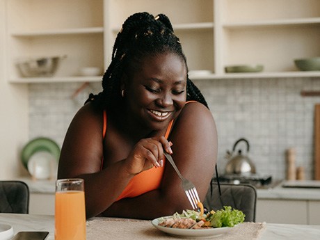 Woman smiling while eating lunch at home