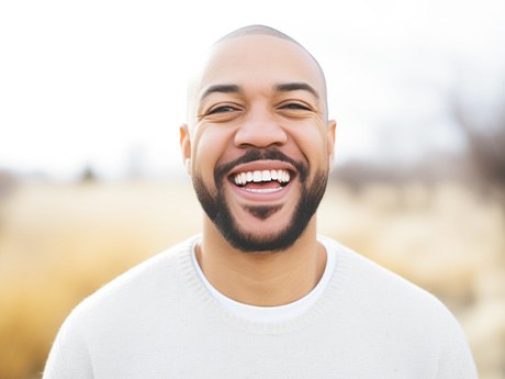 Man in white shirt smiling outside