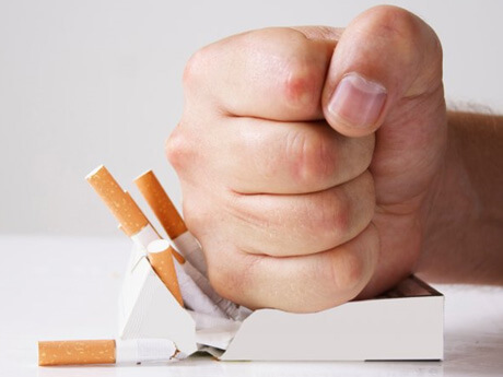 a person smashing a box of cigarettes