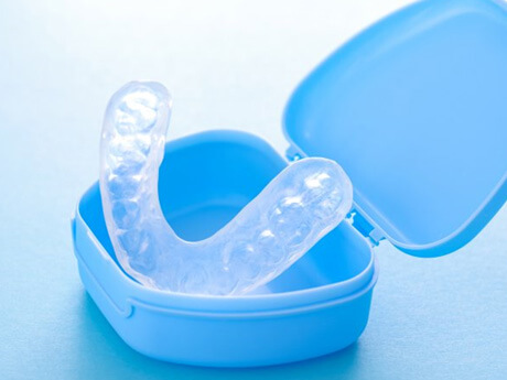 a custom mouthguard inside its protective case