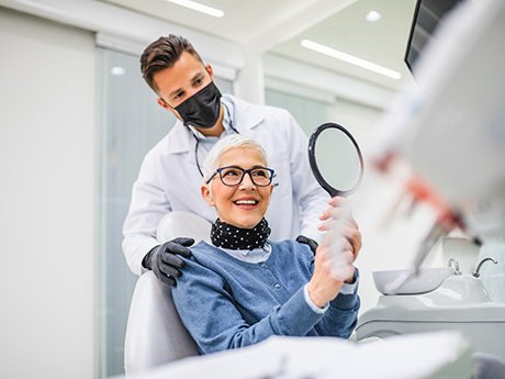 a patient looking into a mirror and smiling